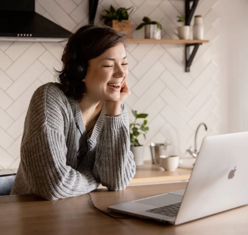 woman are seated next to a table using a laptop to make video calls